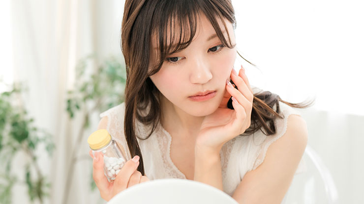 ニキビ薬で治療する女性